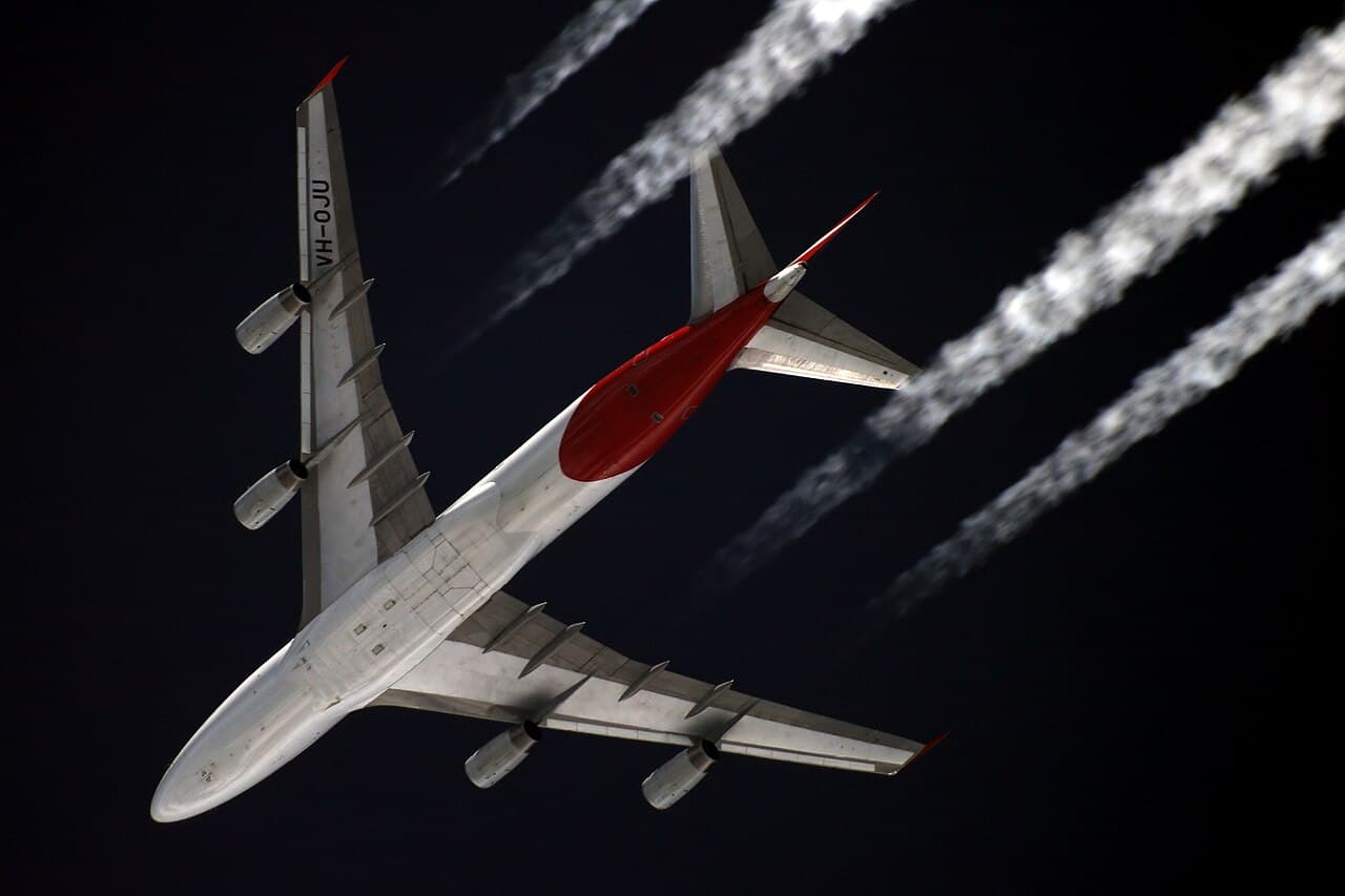 A Qantas Boeing 747-400 flying at approximately 11,000 metres in revised color scheme viewed from the ground at…