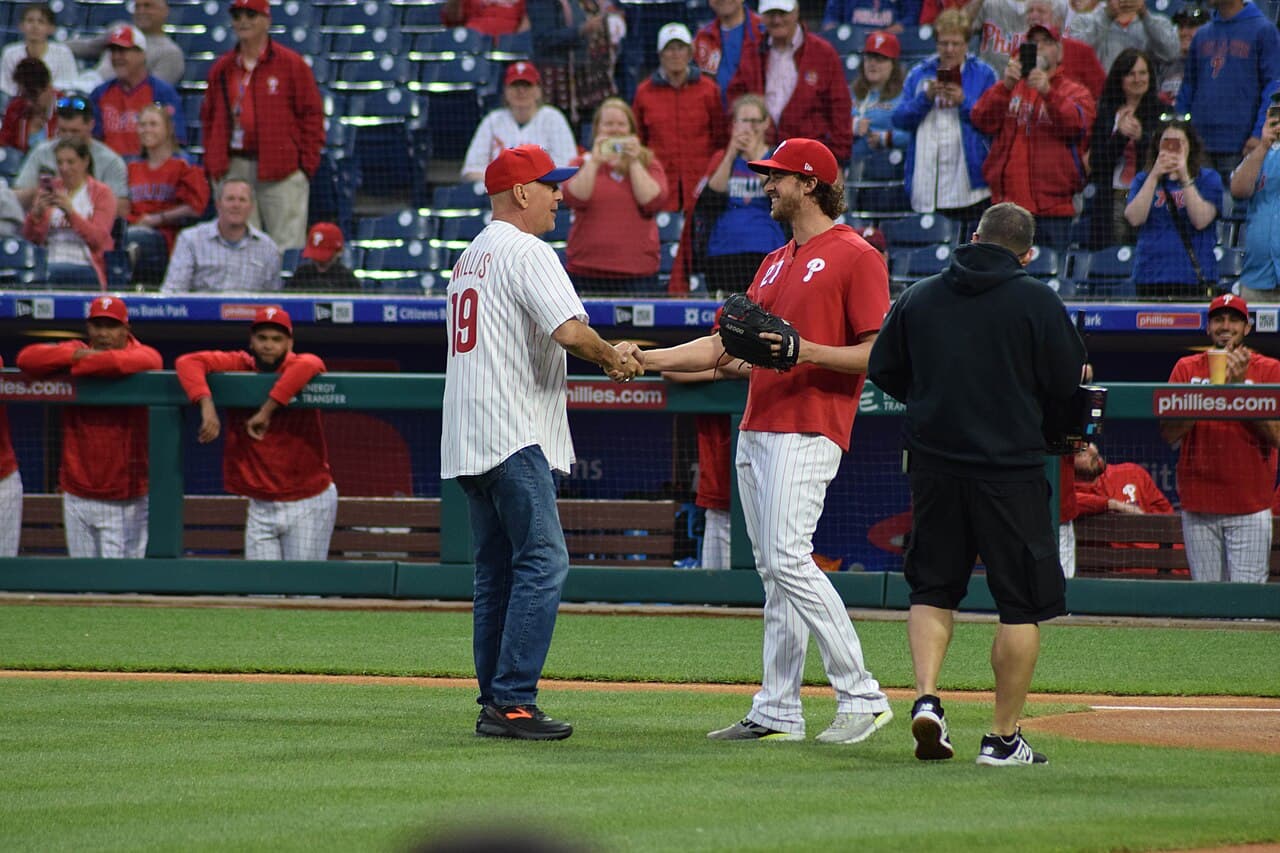 Bruce Willis and Aaron Nola shaking hands after Willis' first pitch at Citizens Bank Park in 2019.