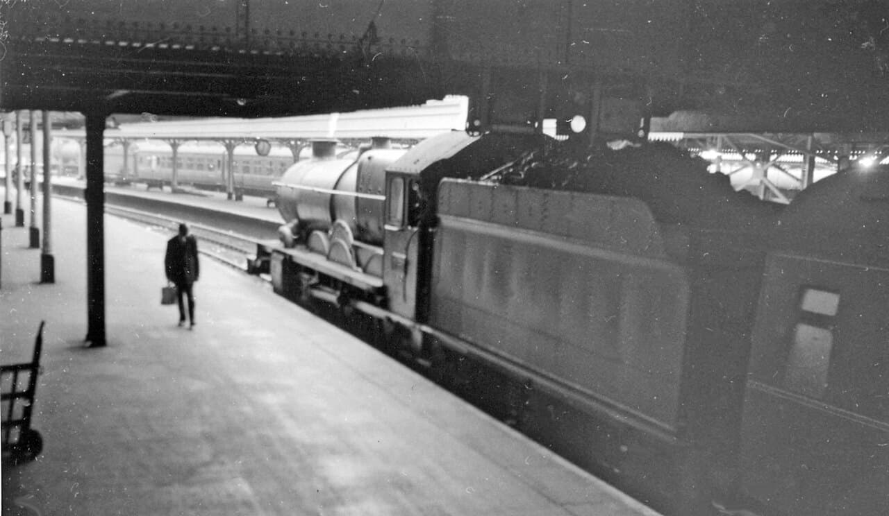 Ex-GW 'Castle' 4-6-0 prepares to leave Paddington on a summer evening. View westward out of the Station, probably on…